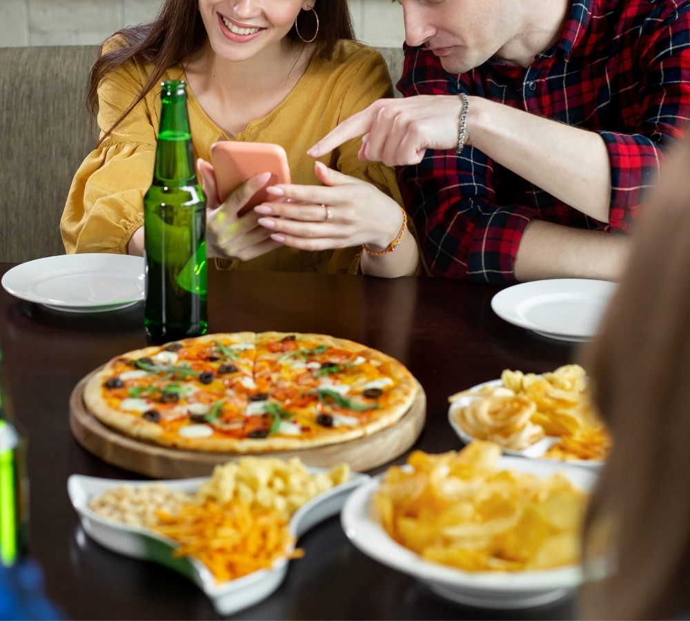 friends in a cafe with pizza and beer having fun