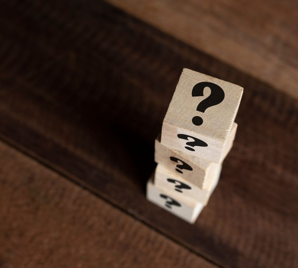 Stacked wooden cube with question mark on table