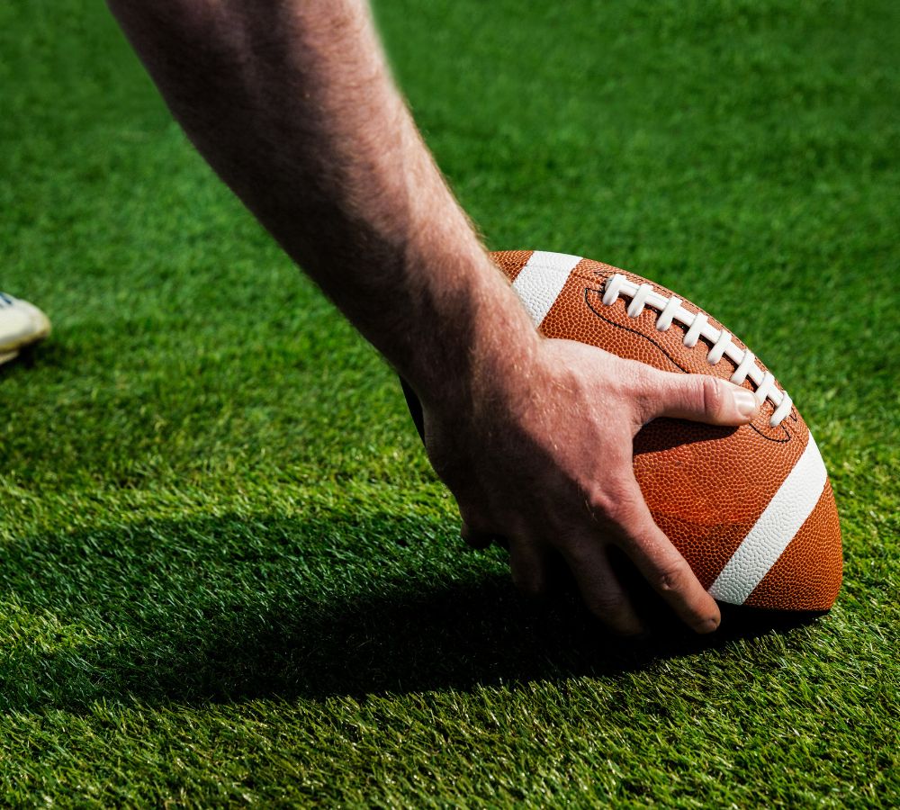 preparing for a drop kick on american football field