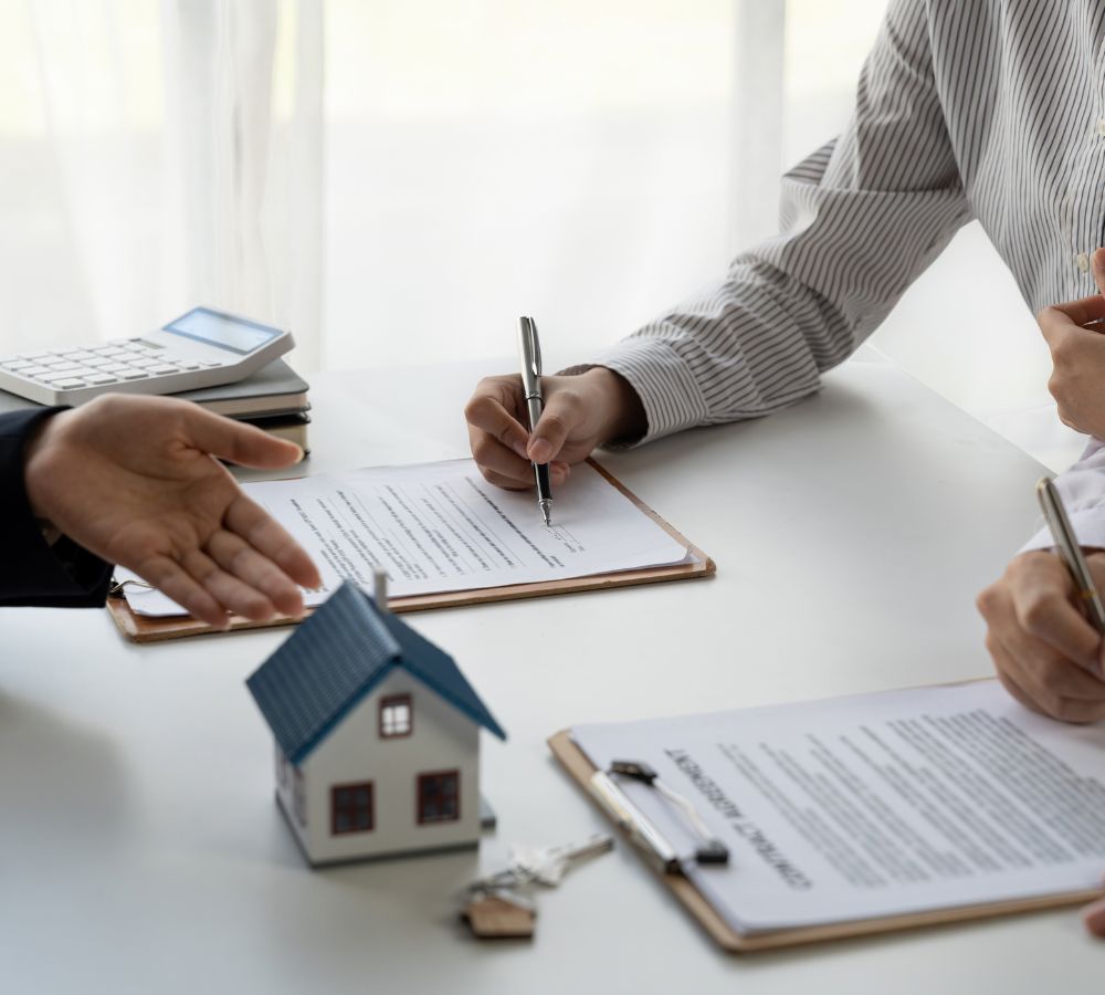 Real estate agent with couple closing a deal